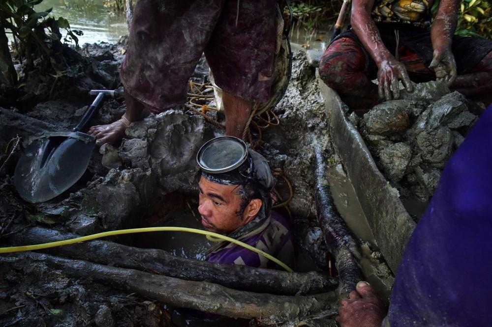 Филиппинский шахтеры рискуют своими жизнями, ныряя в мутные воды в поисках золота