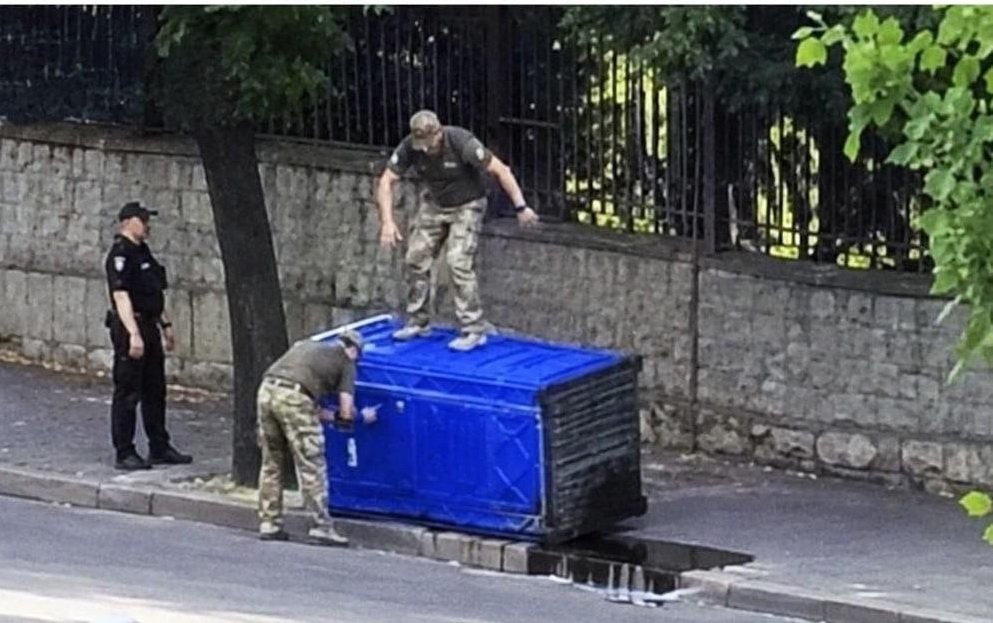 Сотрудники ТЦК Кривого Рога пытаются совершить мобилизационные действия с местным жителем, который укрылся от военных в синей кабинке.